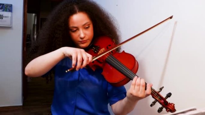 女孩小提琴家在家里演奏小提琴音乐会。音乐家概念。