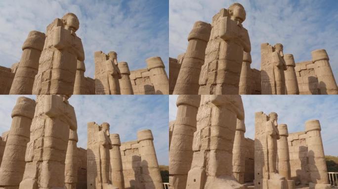 抬头看埃及卡纳克神庙砂岩柱上雕刻的雕像。盘下来
