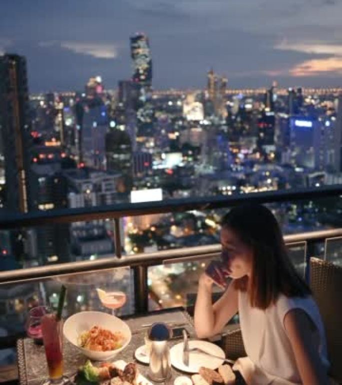 快乐奢华商务成人女性享受美味佳肴，夏日晚上在泰国曼谷户外享受浪漫晚餐