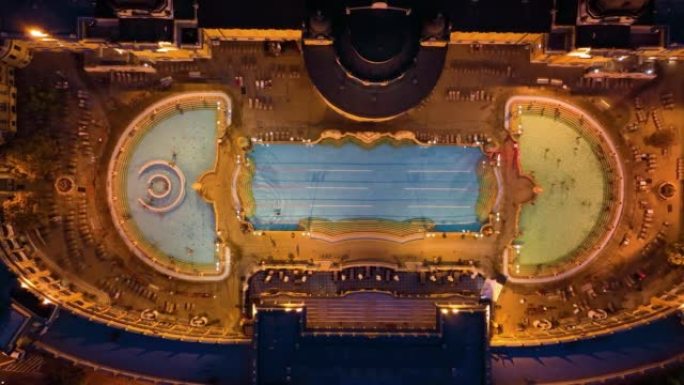 4k空中无人机视图塞切尼浴室。日落后，无人驾驶飞机与许多游客一起在游泳池周围飞行。匈牙利布达佩斯