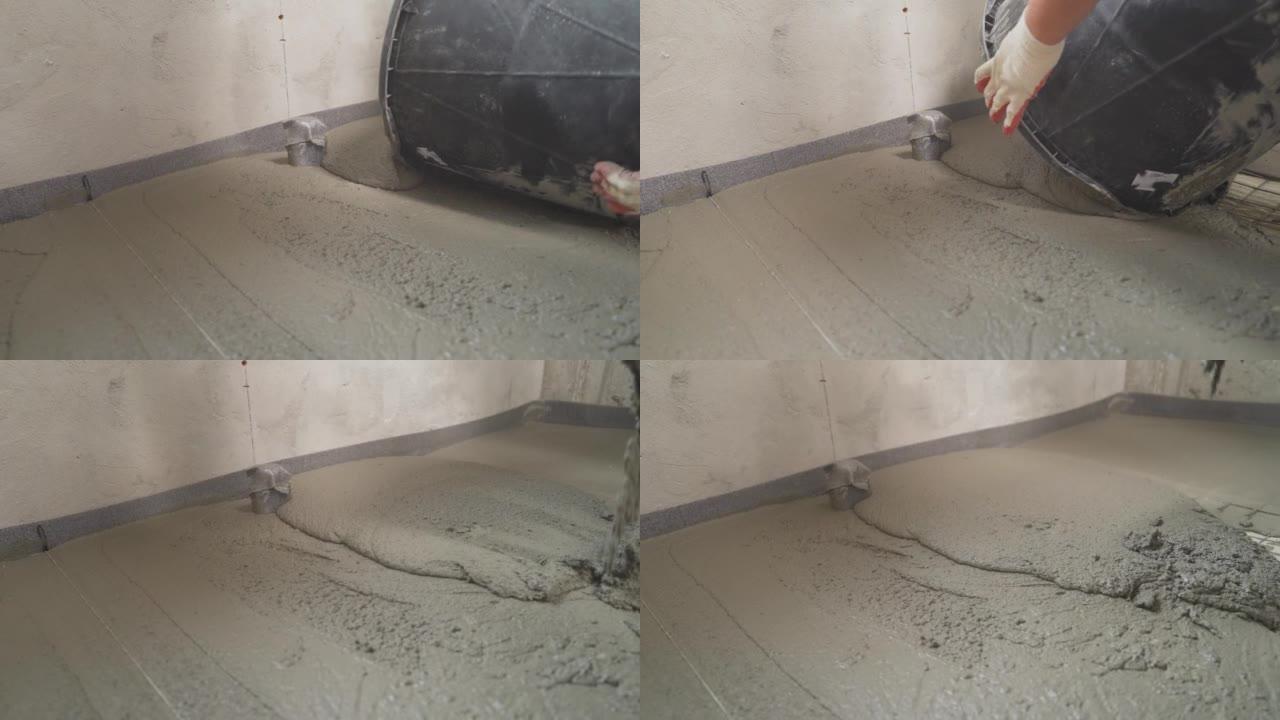 工人用砂浆混合物倒在房间里的地板上。自流平地板。地板修理，液体混合物，找平地板。建筑工人从桶中倒出水