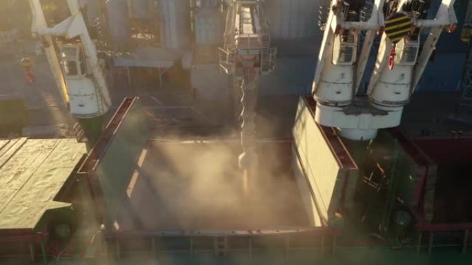 在海港的海粮升降机上，将小麦装载到散装船货舱的鸟瞰图。通过海港码头的移动干线将小麦从筒仓运到船上。海