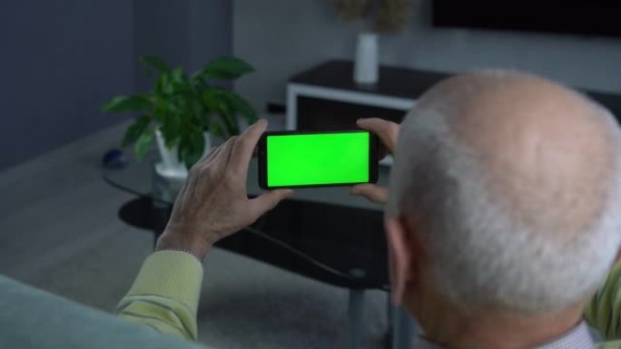 光头老人手持智能手机配绿黑屏