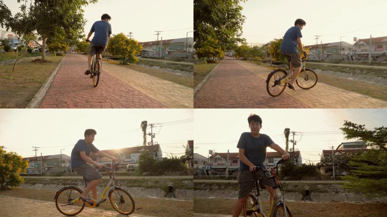 亚洲少年男孩骑自行车在户外的道路上，生活方式的概念。