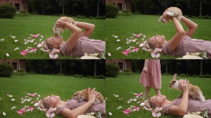 夏天，美丽的年轻女子躺在绿色的草地上，抱着一只复活节兔子