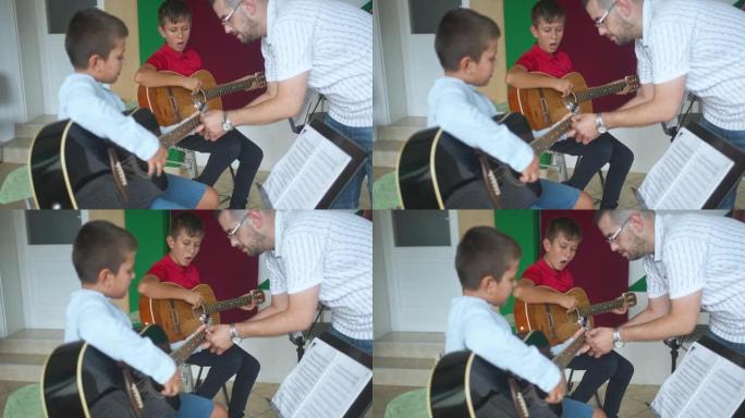 吉他老师帮助学生在课上正确地将手指放在脖子上