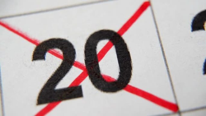 日历中的第20个数字在白纸上的宏中用红叉划掉。计划、笔记、会议日历。商业日历。日历中注释的标记。