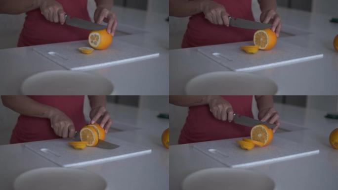 面目全非的女人把橘子水果切成薄片。