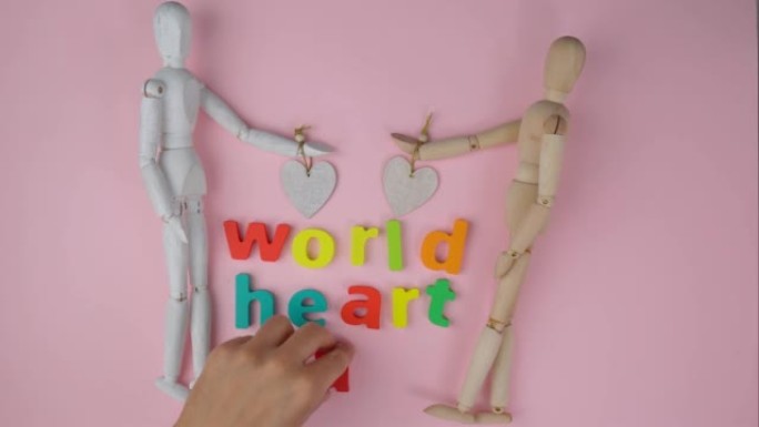 世界心脏日，9月29日上的医疗标志。两个木制人体模型俯视图，粉红色背景