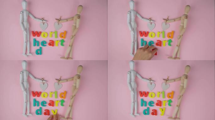 世界心脏日，9月29日上的医疗标志。两个木制人体模型俯视图，粉红色背景