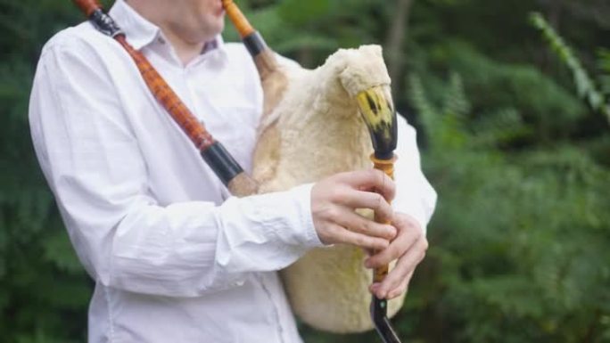 男性民间音乐家在风笛上演奏的优美歌曲