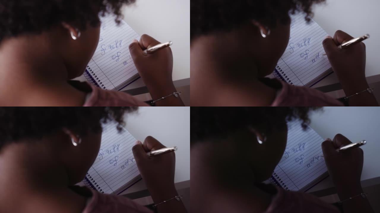 动手。黑人女孩在家在笔记本上画画。