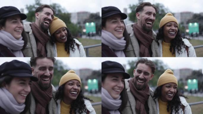 快乐的多元文化朋友在冬天的城市街道户外一起欢笑