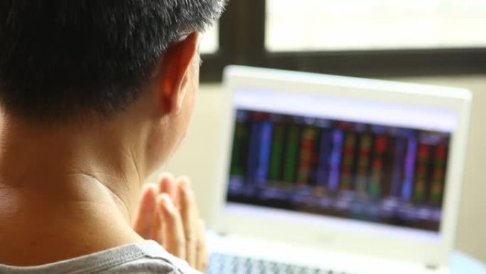 交易者正在通过笔记本电脑监控证券交易所