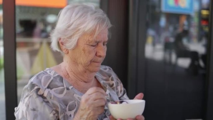 一名高级妇女吃冰淇淋的慢动作视频