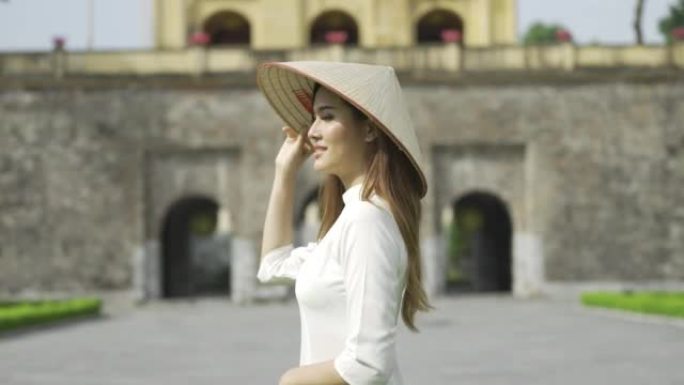 唐龙皇城中穿着传统服饰和圆锥形帽子的越南妇女画像