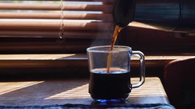 Man pours coffee into a cup in the morning