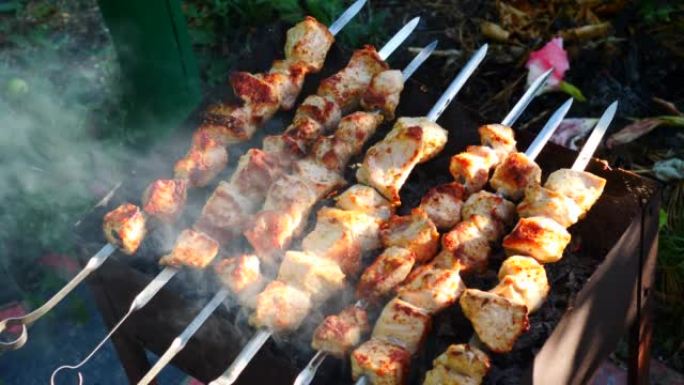 夏天，在火盆的煤上烤了刺入串肉的特写肉。在露天烹饪烤肉，在炸猪肉上抽烟。选择性聚焦