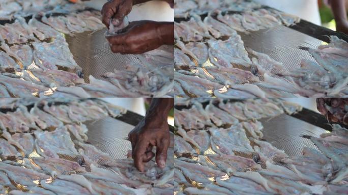 印尼工人安排鱼在阳光下晒干，制成稀薄的咸鱼干