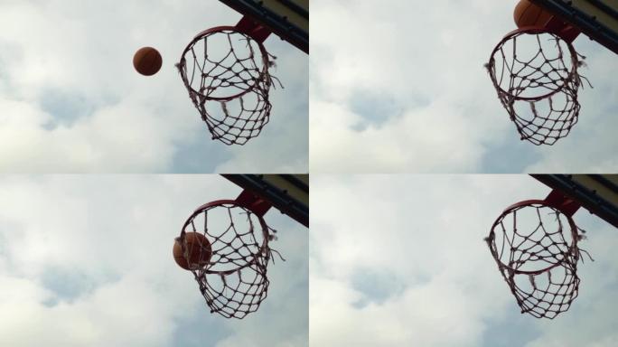 篮球橙色球错过篮筐在多云的天空前慢动作未击中目标。未能得分倒霉的射门从篮筐篮板反弹