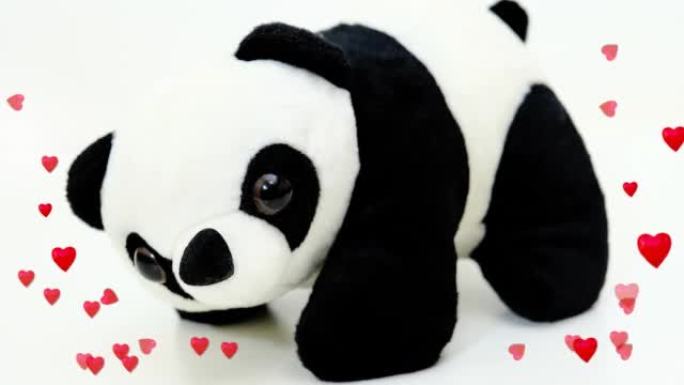 白色背景和飞行动画心脏上的熊猫熊毛绒玩具。生日，庆祝儿童节日概念