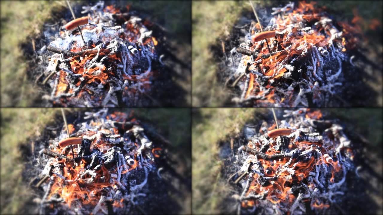 在篝火上烘烤的木棍上的香肠