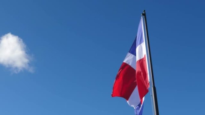 天空背景，风中飘扬的多米尼加共和国国旗