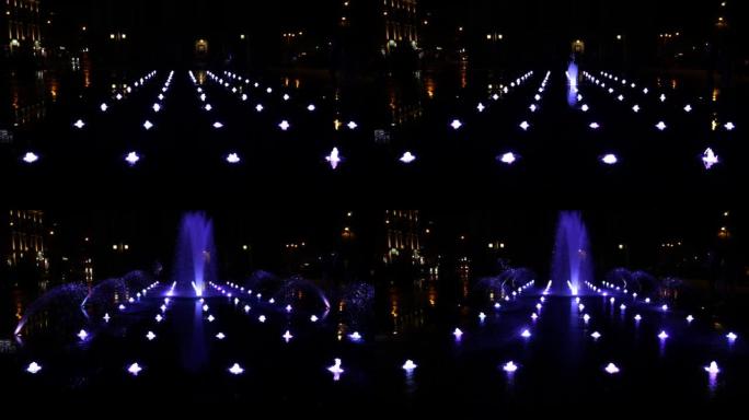 夜城喷泉的喷水带照明。
