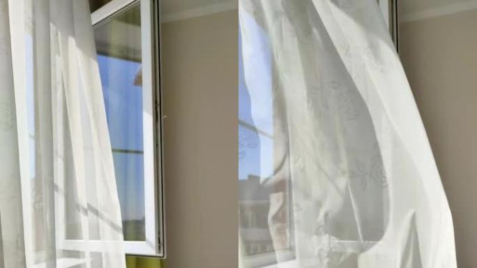 透明的白色窗帘随风移动，房子里开着窗户