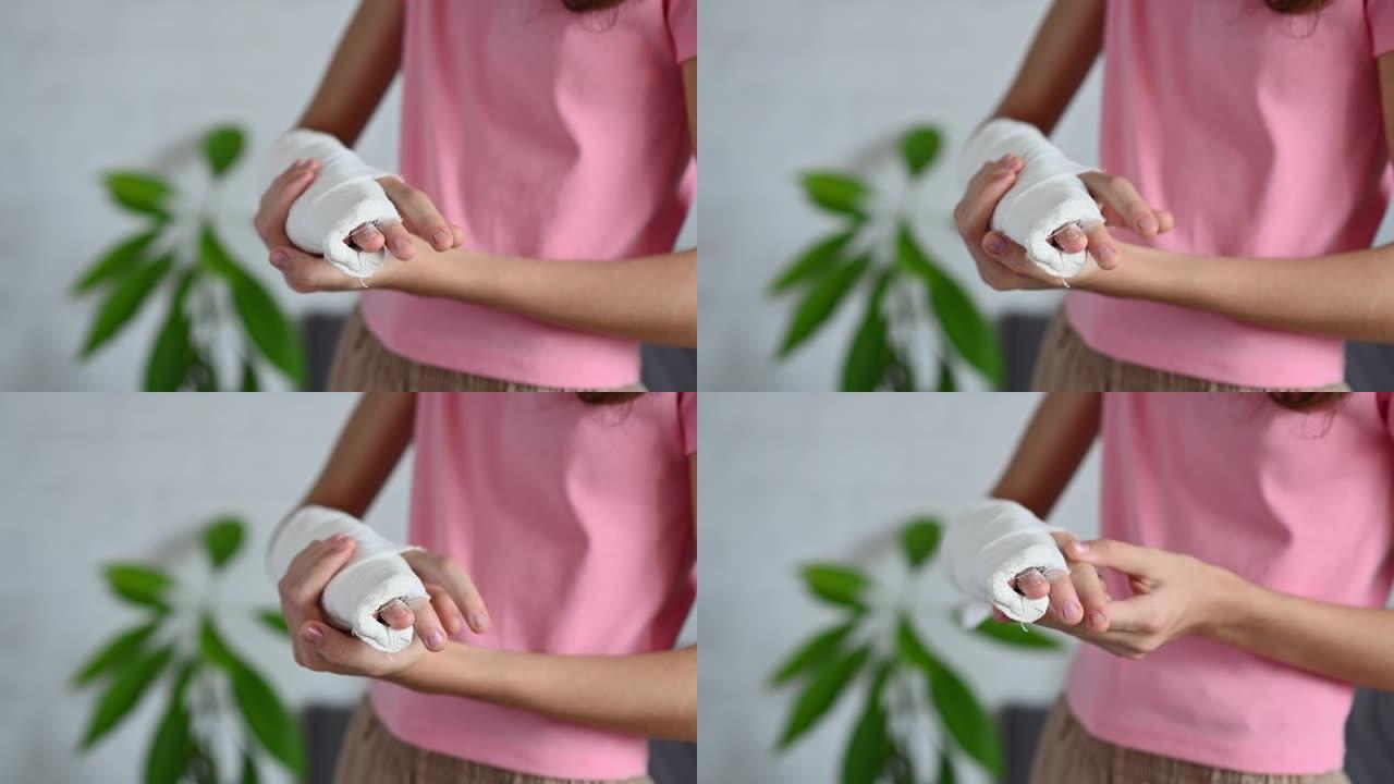 一个手臂骨折的女孩试图移动手指的特写镜头。手部受伤。