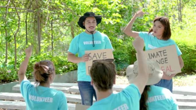 两名亚洲志愿者领袖为应对气候变化全球变暖提供指示，并举着有关环境灾难的标语。团体积极分子倾听导师并举