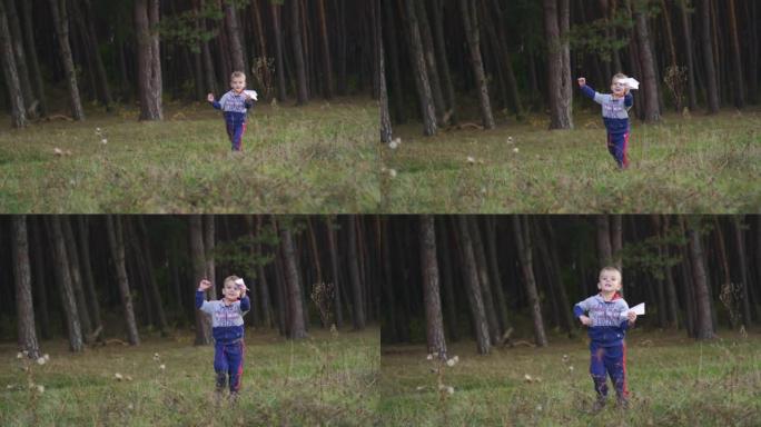 一个小男孩玩玩具飞机，在公园里奔跑。自由梦想概念。