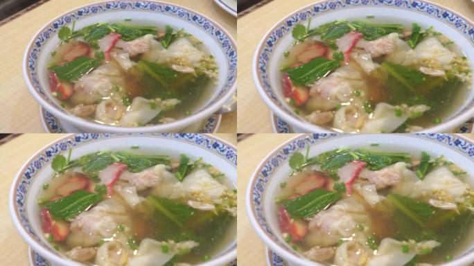 在白碗里吃馄饨汤和烧烤肉。塞满虾和蔬菜的小麦面团水饺。白碗大虾饺子汤 -- 亚洲美食风格