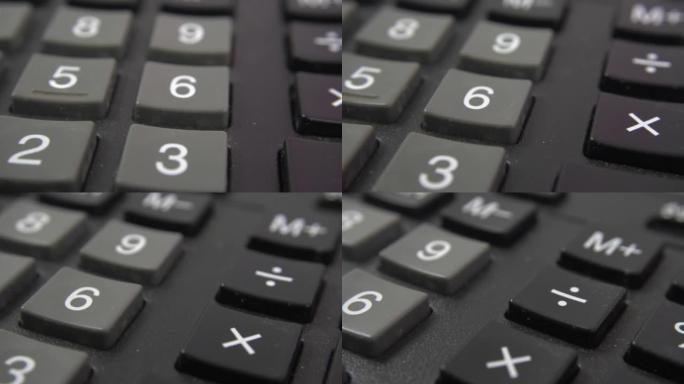 计算器键盘特写视图。黑色计算器按钮，选择性对焦。一种大量使用的旧会计工程计算器，按钮之间有污垢。多莉