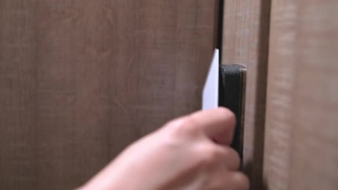 女人的手将钥匙卡放在面板上并打开门特写