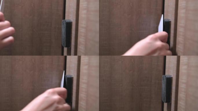 女人的手将钥匙卡放在面板上并打开门特写
