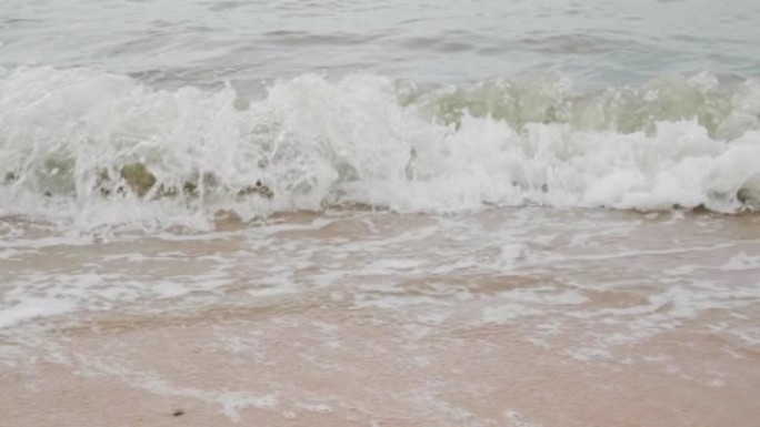 海滩上的慢动作泡沫波。雨季雨后和强烈海浪的海滩