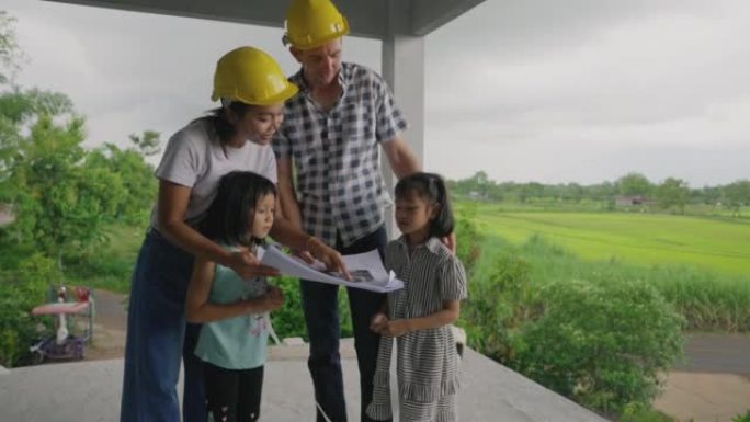 多民族融合的四口之家聚集并检查了他们的新家的建设。