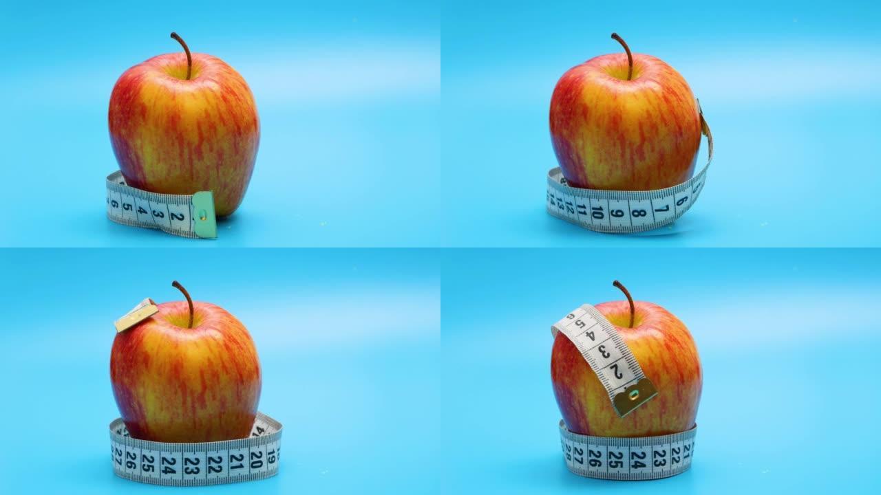 卷尺被包裹在红苹果上。健康食品，饮食，减肥理念。停止运动动画。