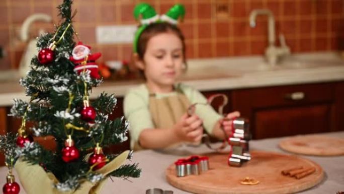 选择性地将注意力集中在桌子上的圣诞树上，以对抗一个模糊的儿童女孩喜欢玩姜饼切刀