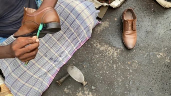 在印度加尔各答的mochee或可怜的补鞋匠的特写视频，用黑色鞋油抛光顾客的鞋子