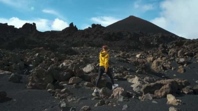 女旅行者在特内里费岛泰德国家公园的钦耶罗火山周围的熔岩田野中漫步。去任何地方。另一个星球的表面。