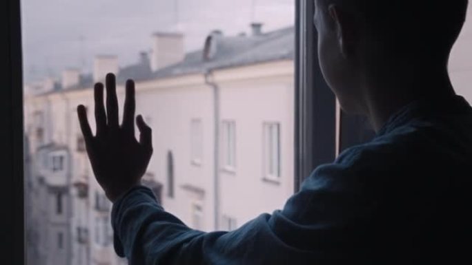 男孩的手在窗户上移动，背景是苏联的房子，童年经历，没有战争，电影镜头