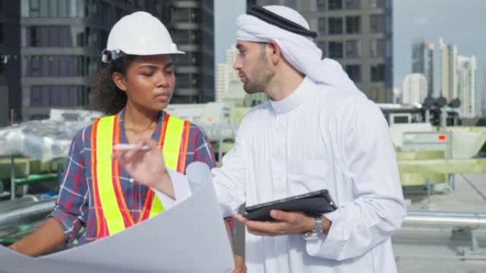 中东阿拉伯投资商和建筑工程师在建筑城市背景下，用平板电脑考察房地产项目施工现场