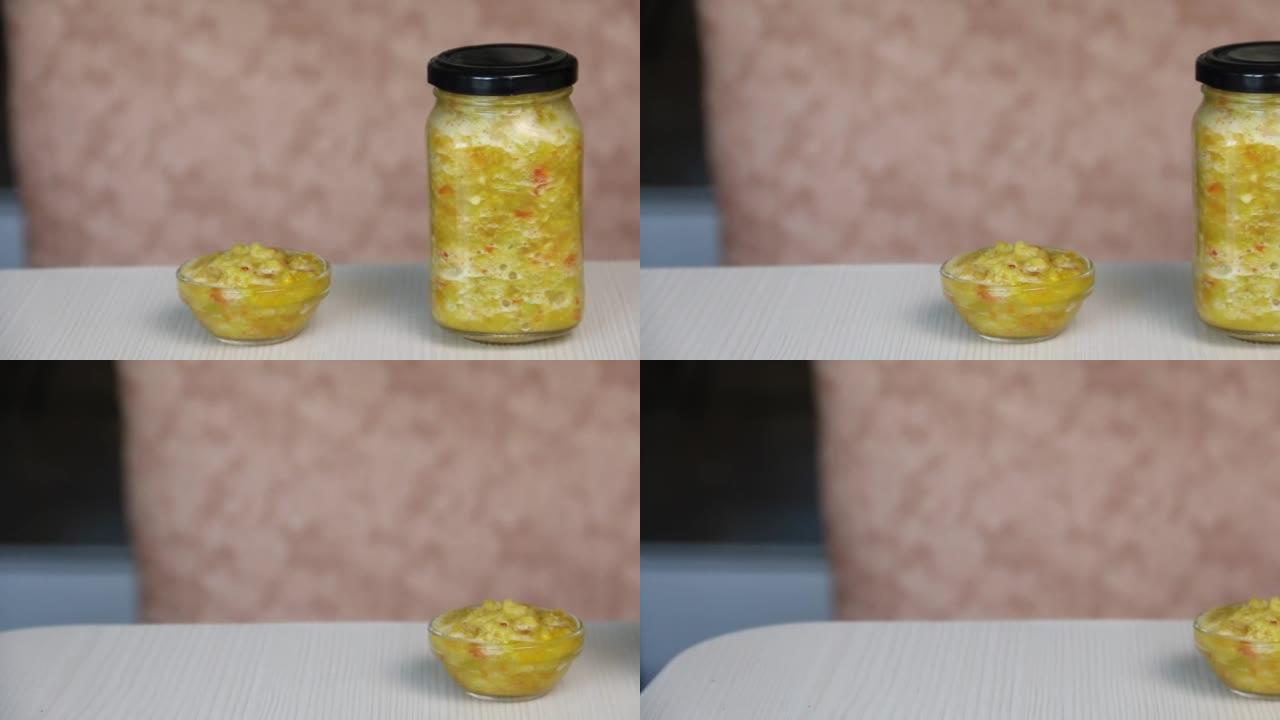 一个装有刚准备好的adjika的罐子。它在桌子上。来自红辣椒和青椒的Adjika。为冬天做准备。摄像