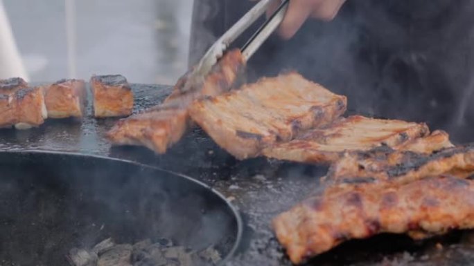 慢动作: 厨师用钳子在火盆上烤肉排