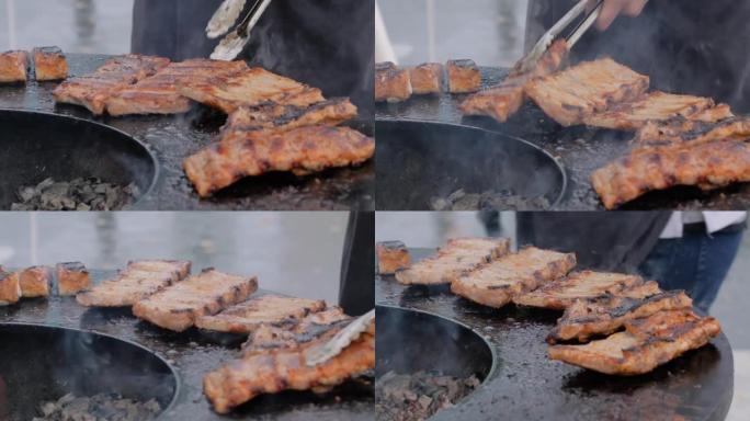 慢动作: 厨师用钳子在火盆上烤肉排