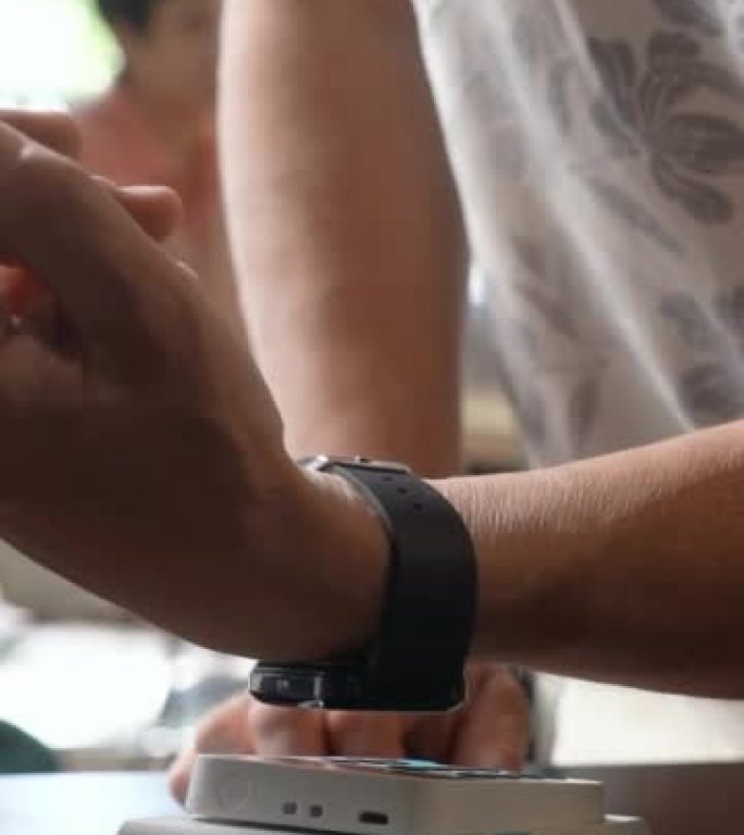 An elder man pay the bill with smart watch wireles