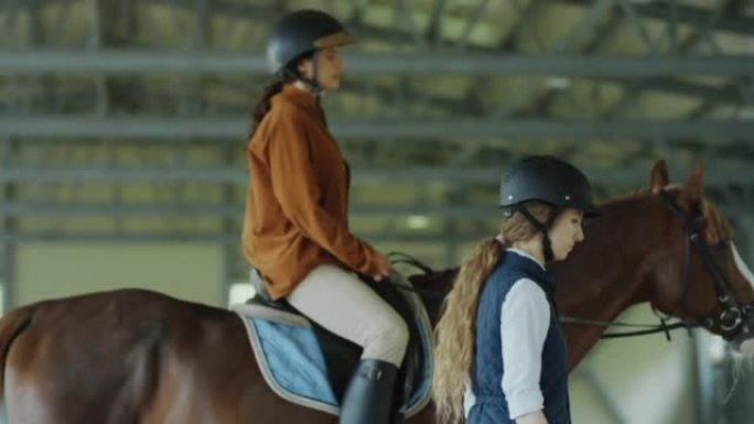女人与教练一起练习骑马