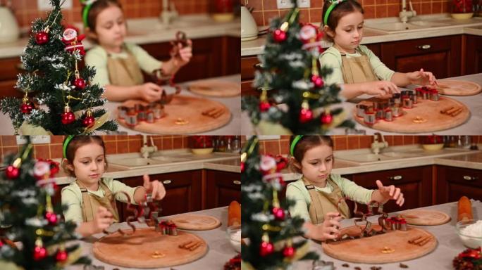 观看圣诞树，并在家庭厨房里一个拿着姜饼切刀的漂亮的孩子女孩身上改变焦点